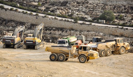 Parc d'engins de chantier : pelles hydrauliques, tombereaux et camions bennes