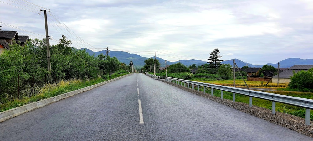 a long empty road with mountains in the background