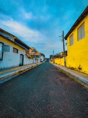 a street with yellow buildings and a blue sky