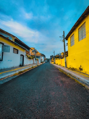 a street with yellow buildings and a blue sky