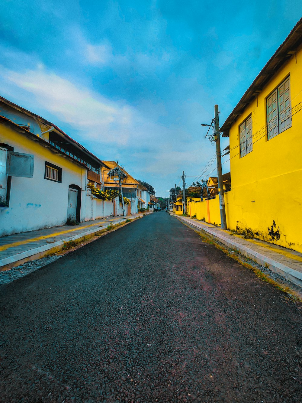 a street with yellow buildings and a blue sky
