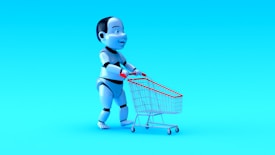 A humanoid robot with exaggerated features is pushing a small shopping cart against a bright blue background. The robot has a shiny, metallic finish with black and white segments, and the shopping cart has a red handle and frame.