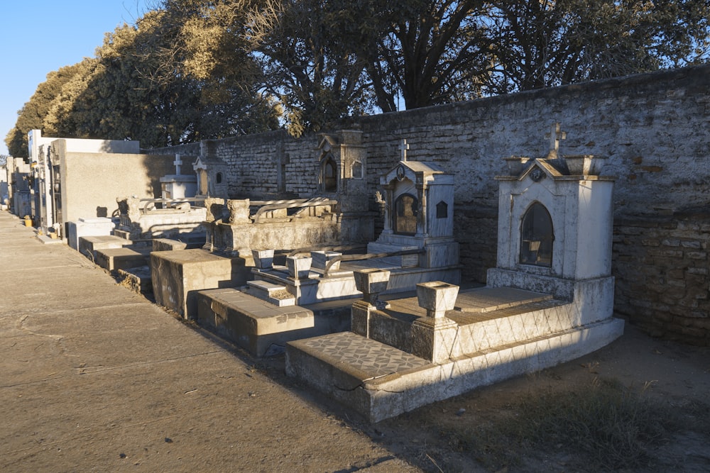 a row of graves in front of a brick wall