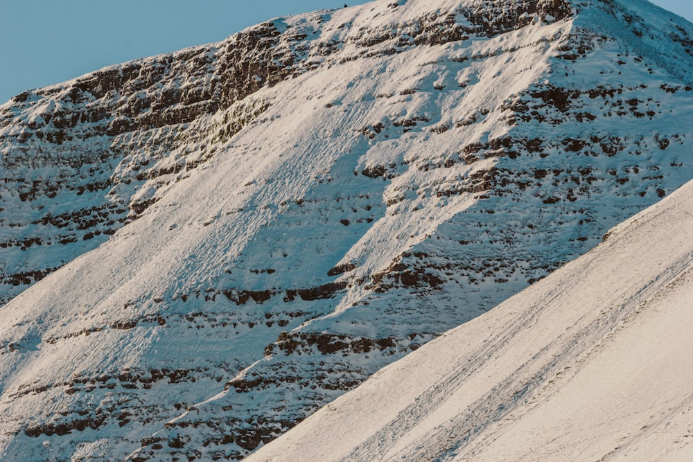 a man riding a snowboard down the side of a snow covered slope