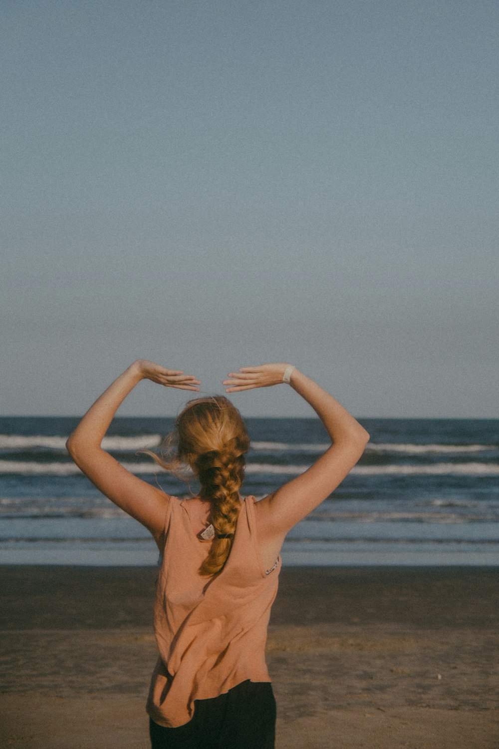 a woman standing on top of a beach next to the ocean