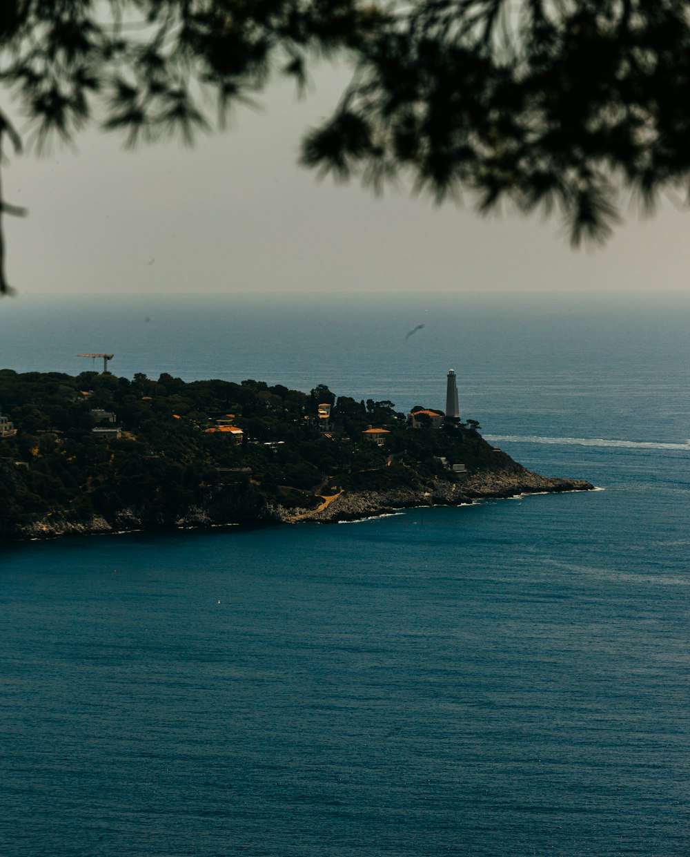 a small island with a lighthouse in the distance