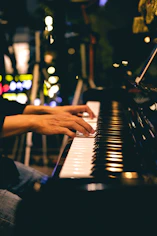 Playing a piano in a dim room with colorful background lights