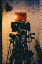 a camera on a tripod in front of a brick wall