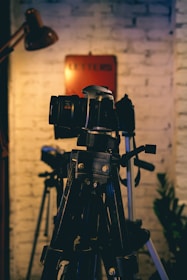 a camera on a tripod in front of a brick wall