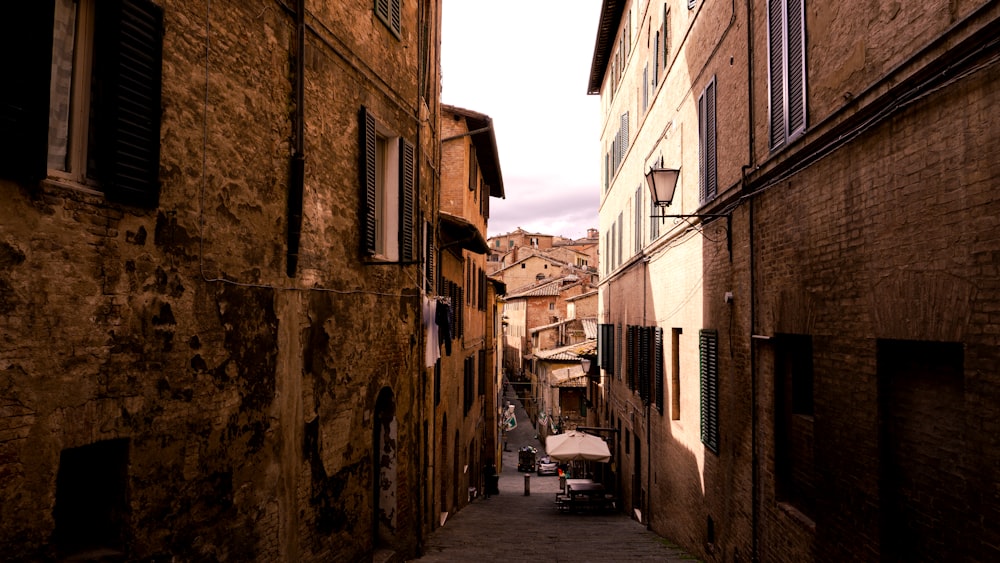 a narrow alley way with a car parked on the side