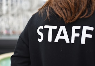 a person wearing a black shirt that says staff