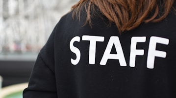 a person wearing a black shirt that says staff