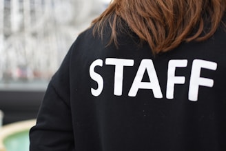 a person wearing a black shirt that says staff