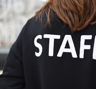 a person wearing a black shirt that says staff