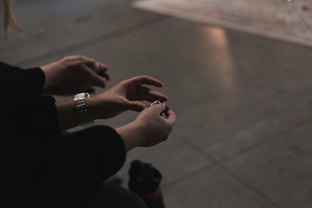 a person sitting on the ground using a cell phone