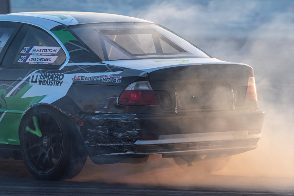 a black and white car driving on a track