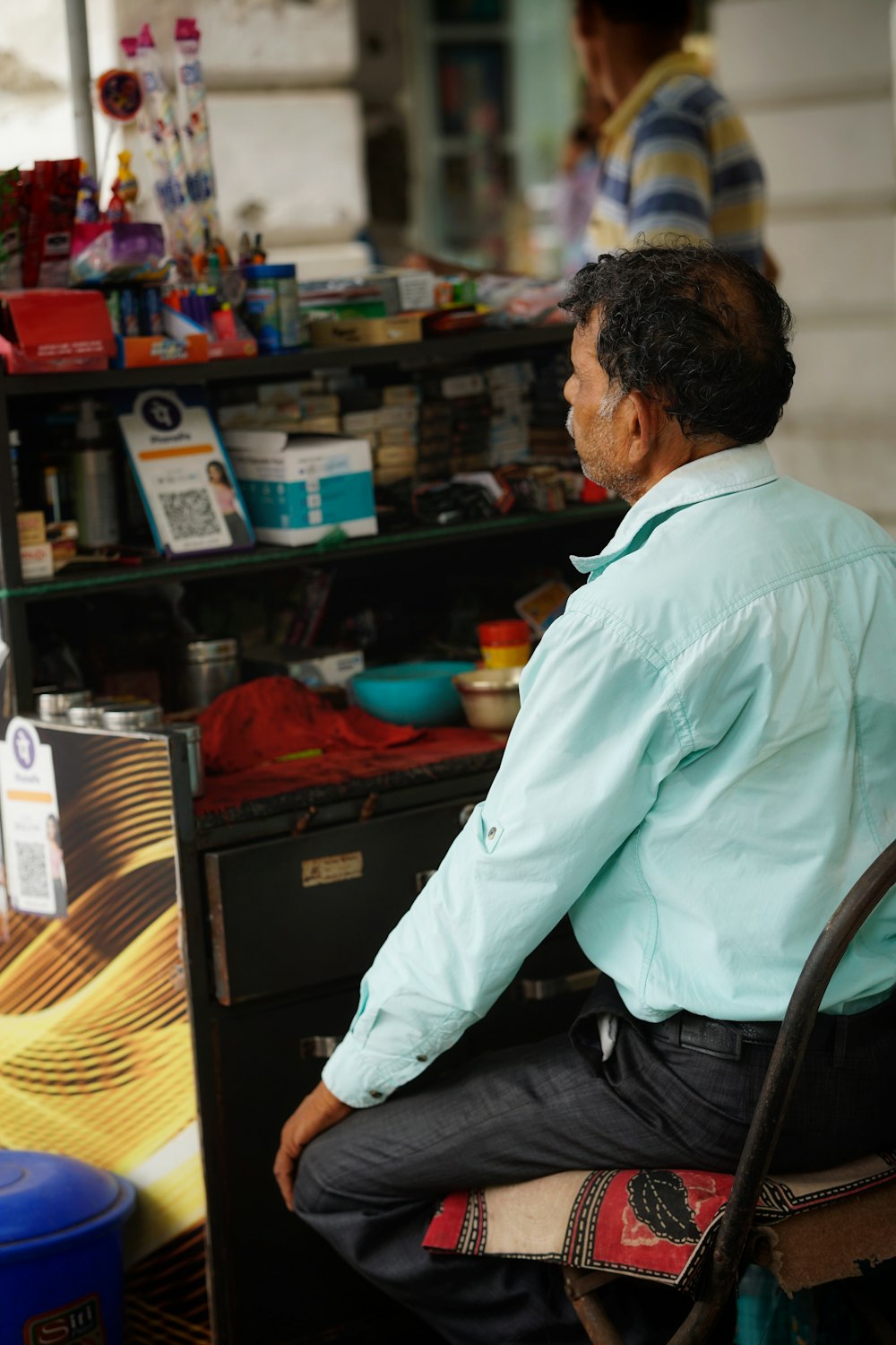 a man sitting in a chair in front of a store