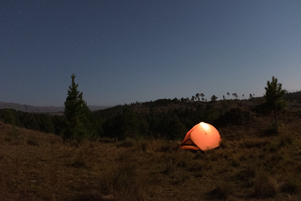 a tent pitched up in a field at night