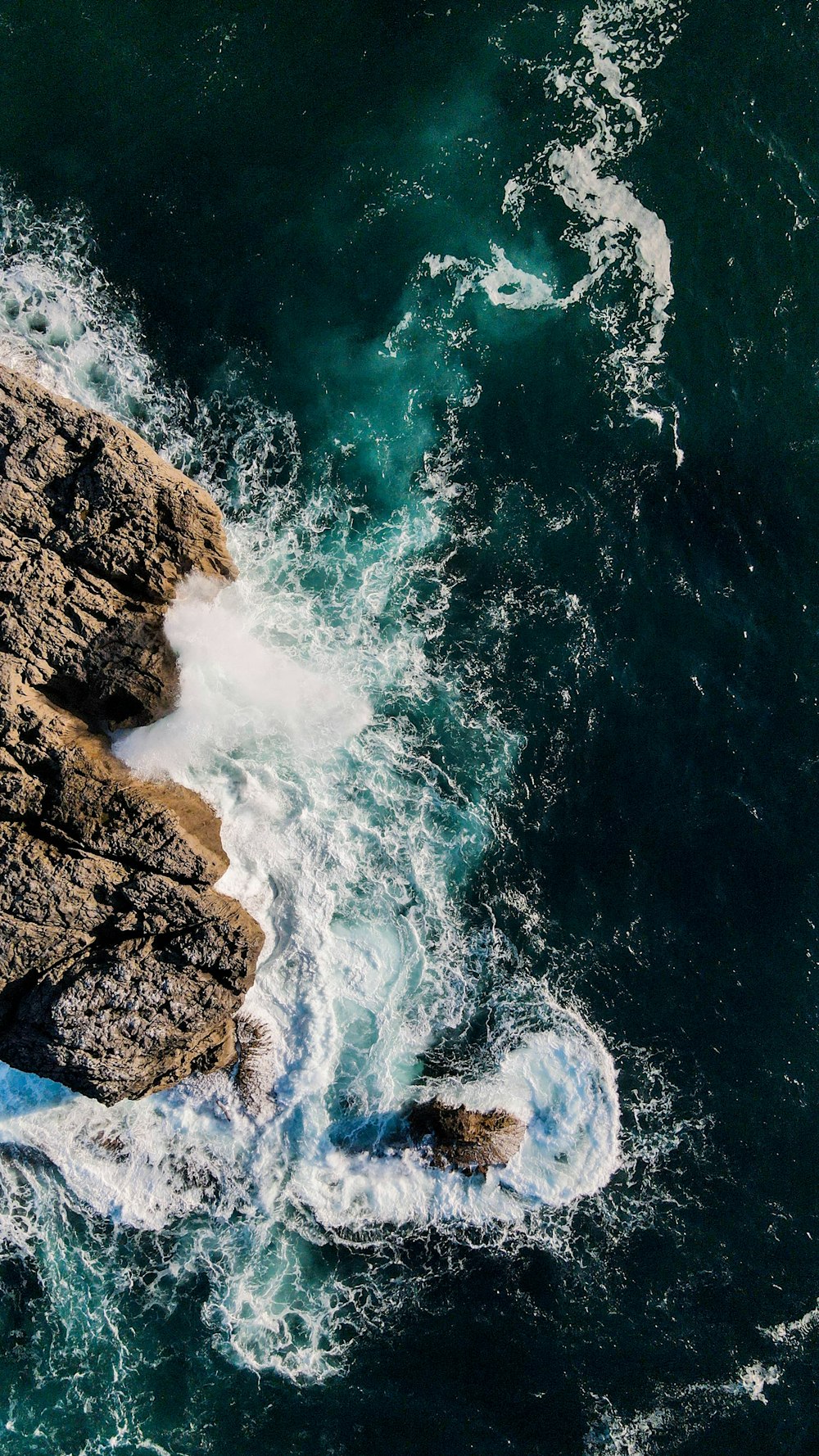 a bird's eye view of the ocean and rocks