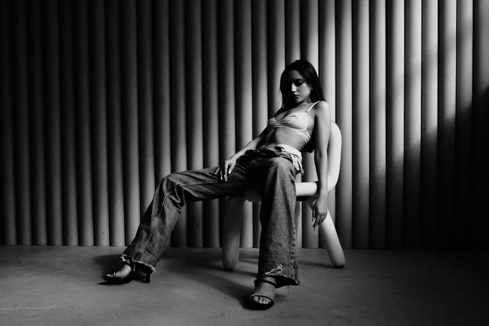 a black and white photo of a woman sitting on a chair