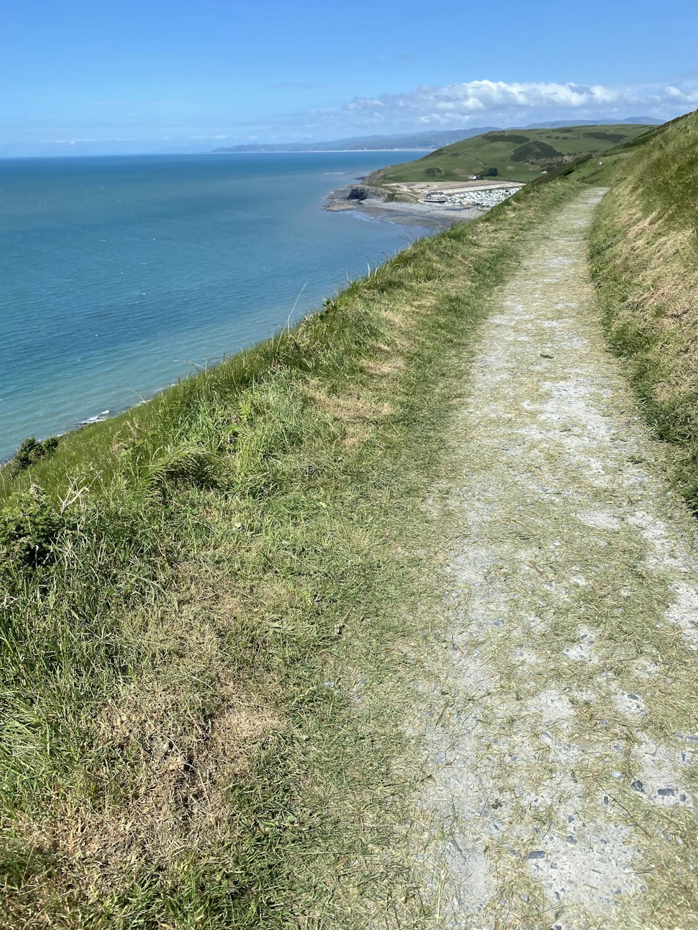 a path leading to the ocean on a sunny day