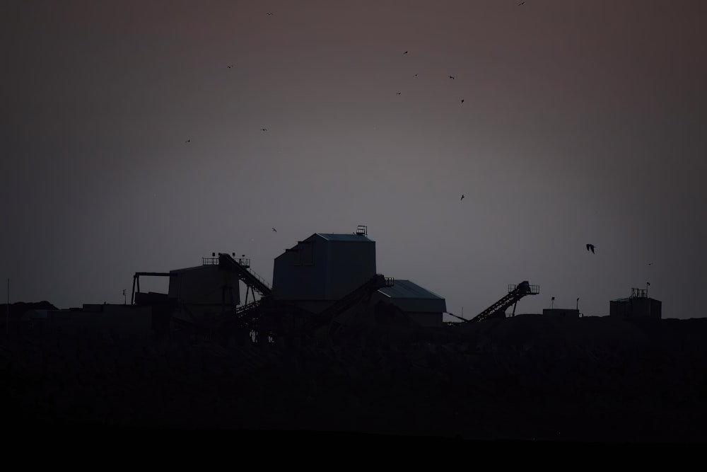 a grain silo in silhouette against a dark sky