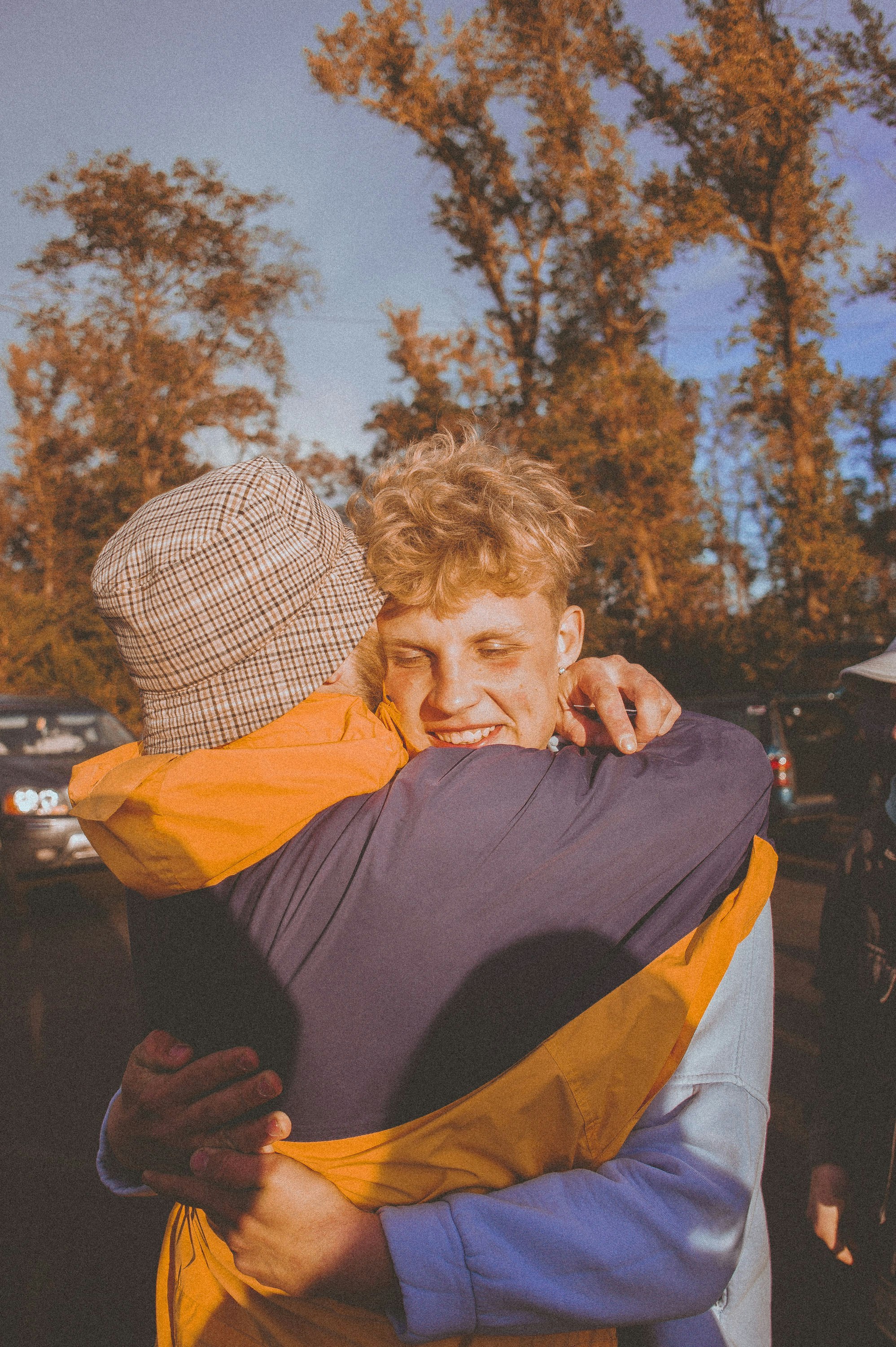 two people hugging each other in a parking lot