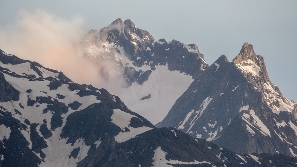 Una montagna coperta di neve con un uccello che vola sopra di essa