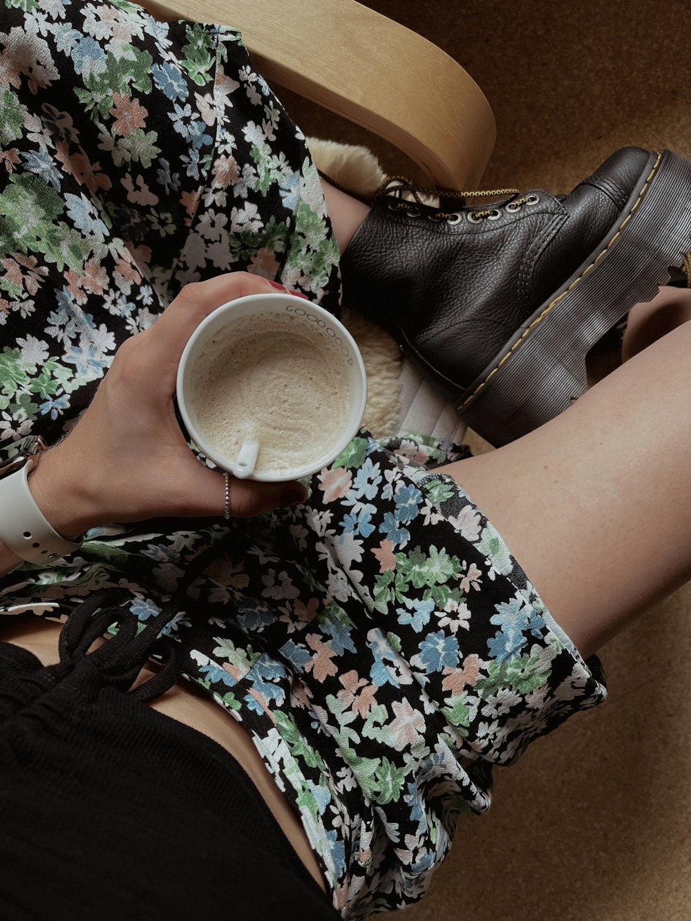 a woman sitting on a chair holding a cup of coffee