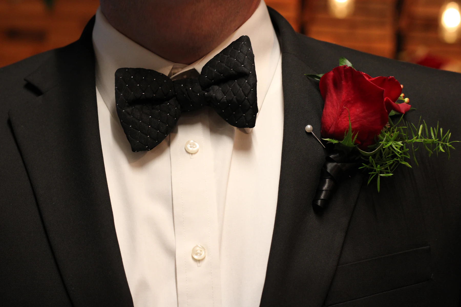 Black tuxedo with a textured bow tie and boutonniere