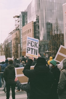 a group of people holding up signs on a city street