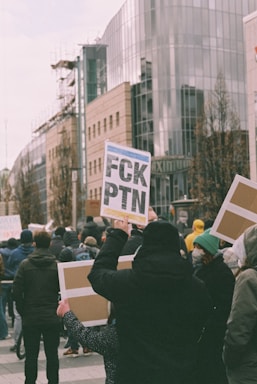 a group of people holding up signs on a city street