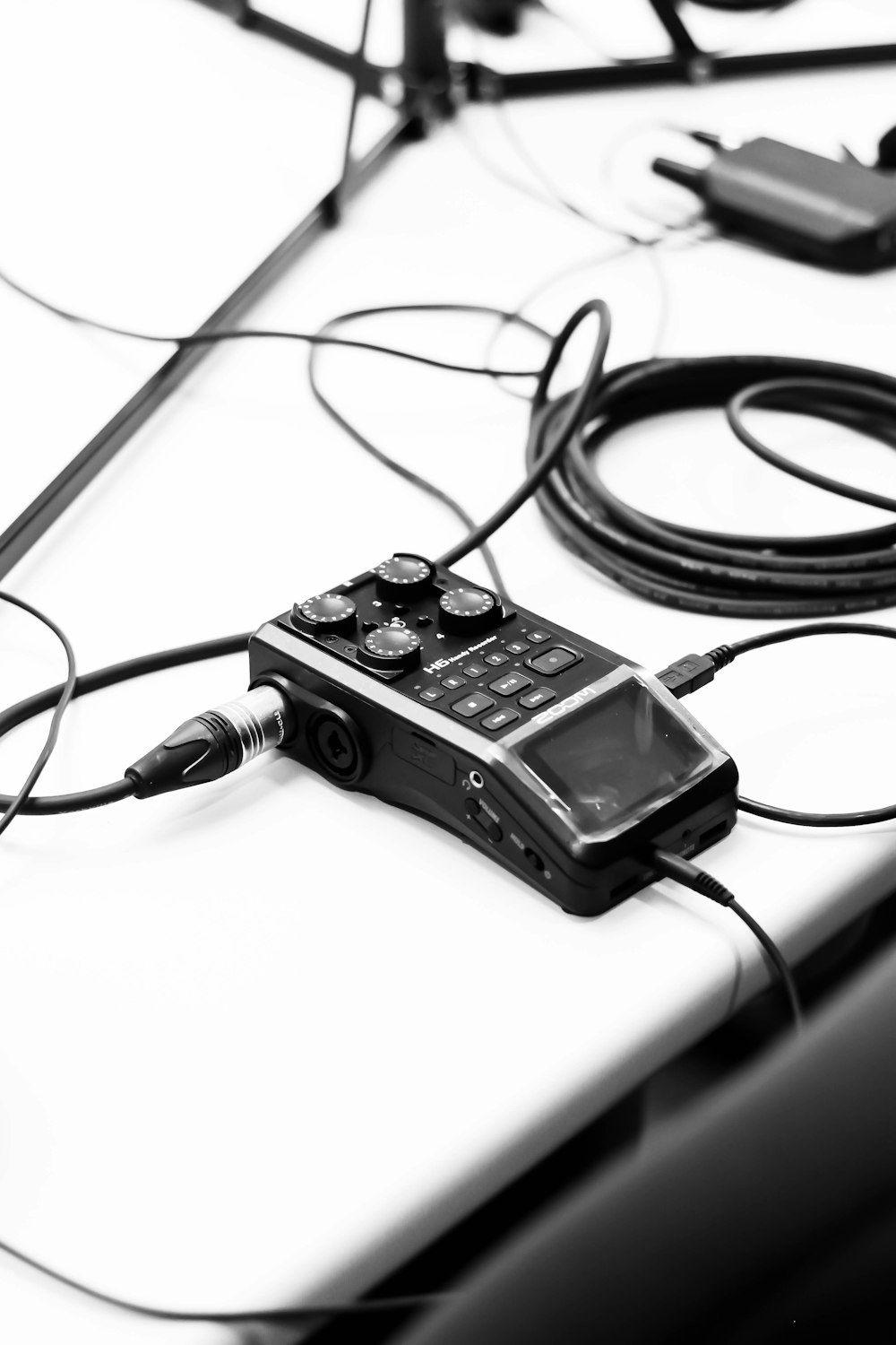 a black and white photo of a cell phone and wires