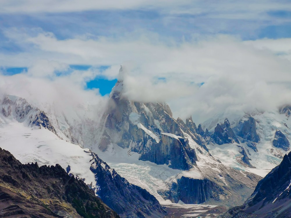 a mountain range covered in snow and clouds