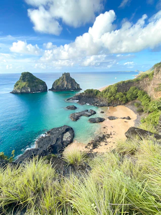 a beach with a few rocks in the water