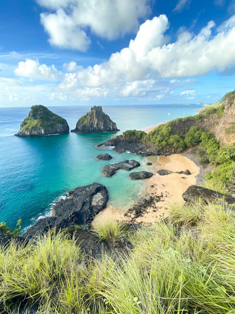 a beach with a few rocks in the water