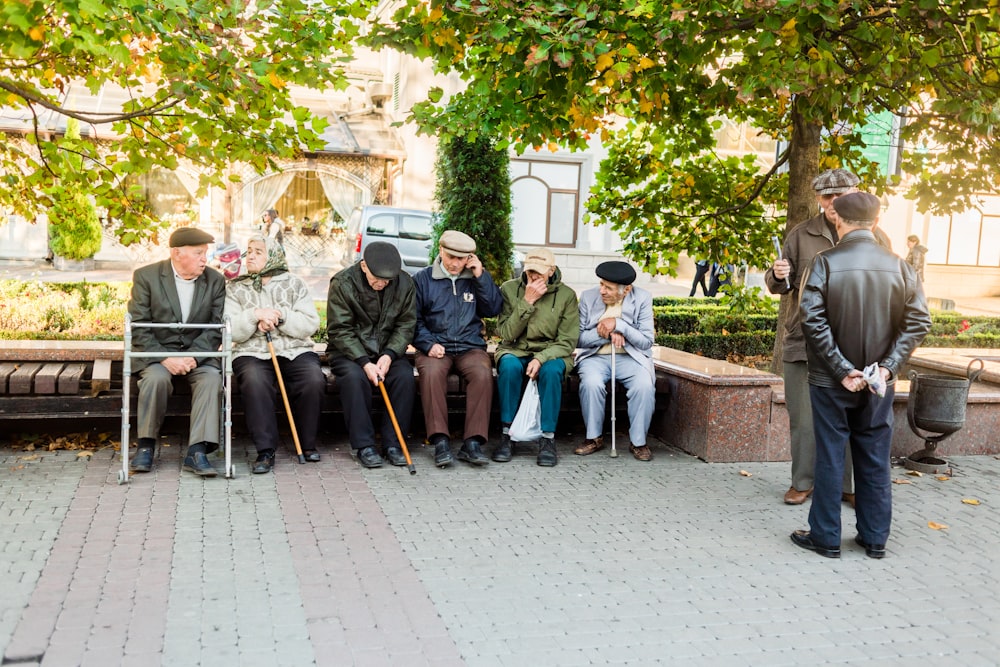 a group of people sitting next to each other on a bench