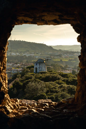 a view of a town through a hole in a rock