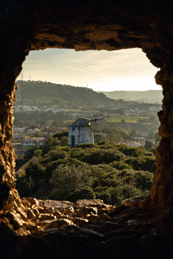 a view of a town through a hole in a rock