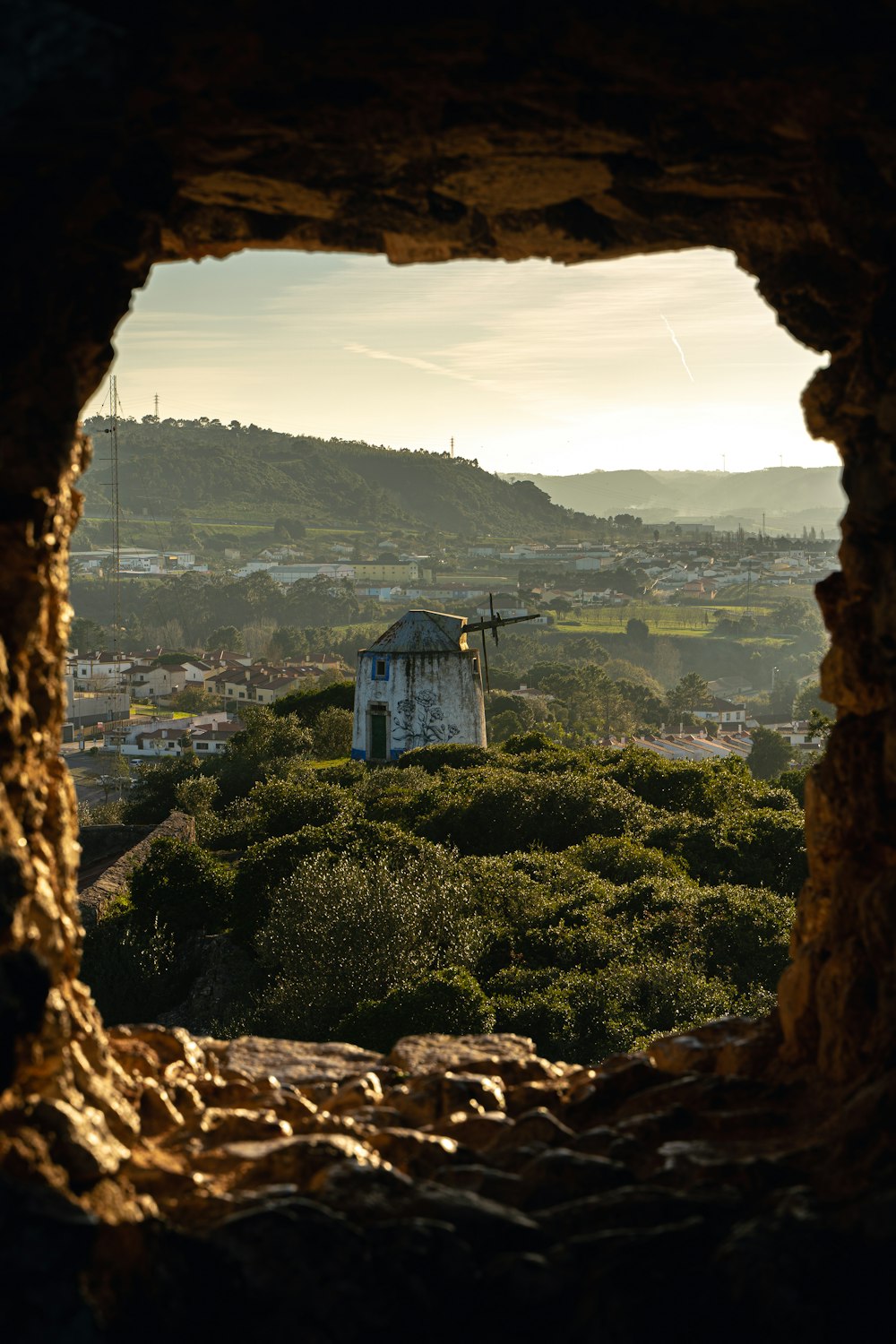 a view of a town through a hole in a rock