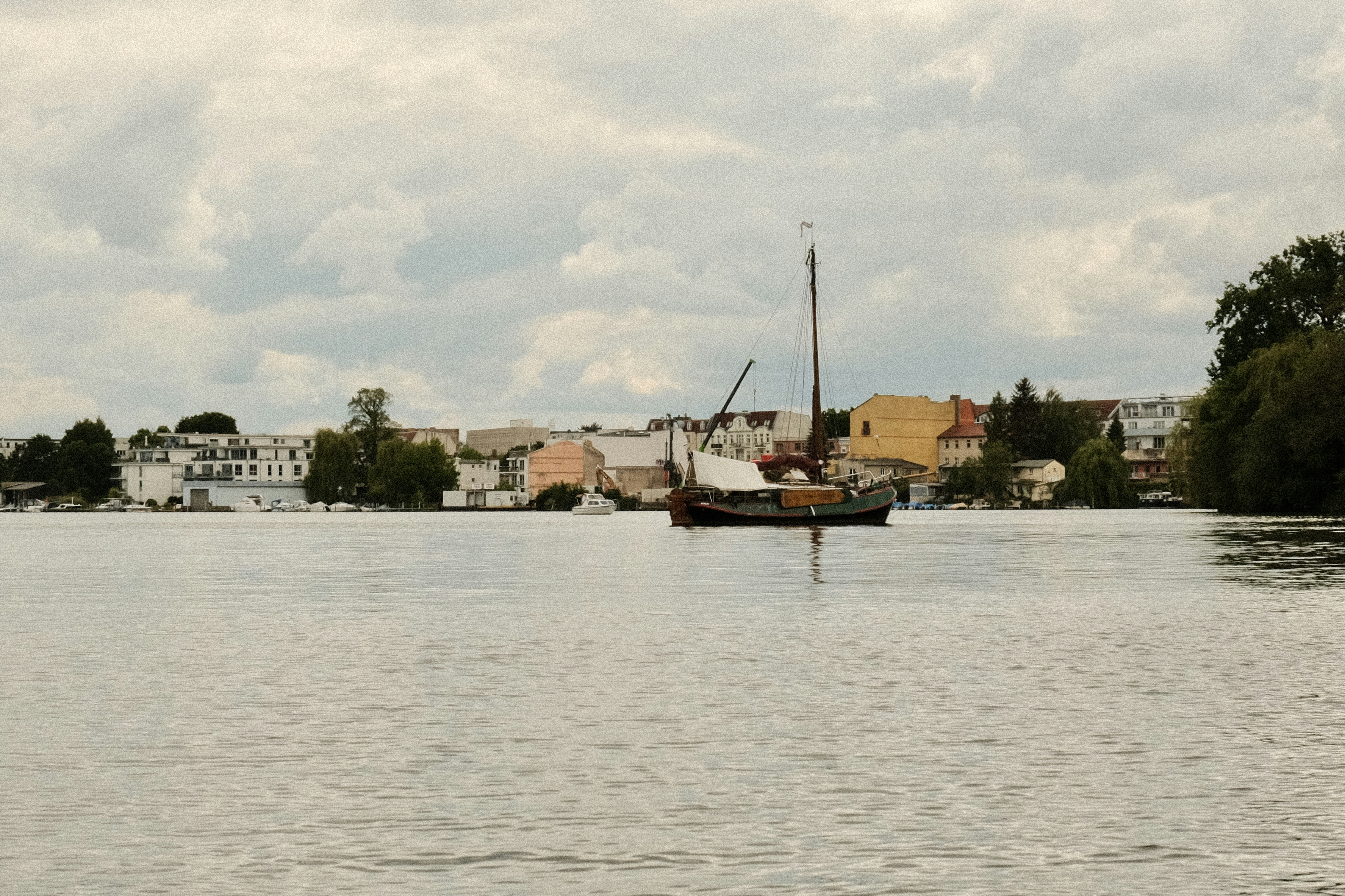 a boat floating on top of a lake next to a town