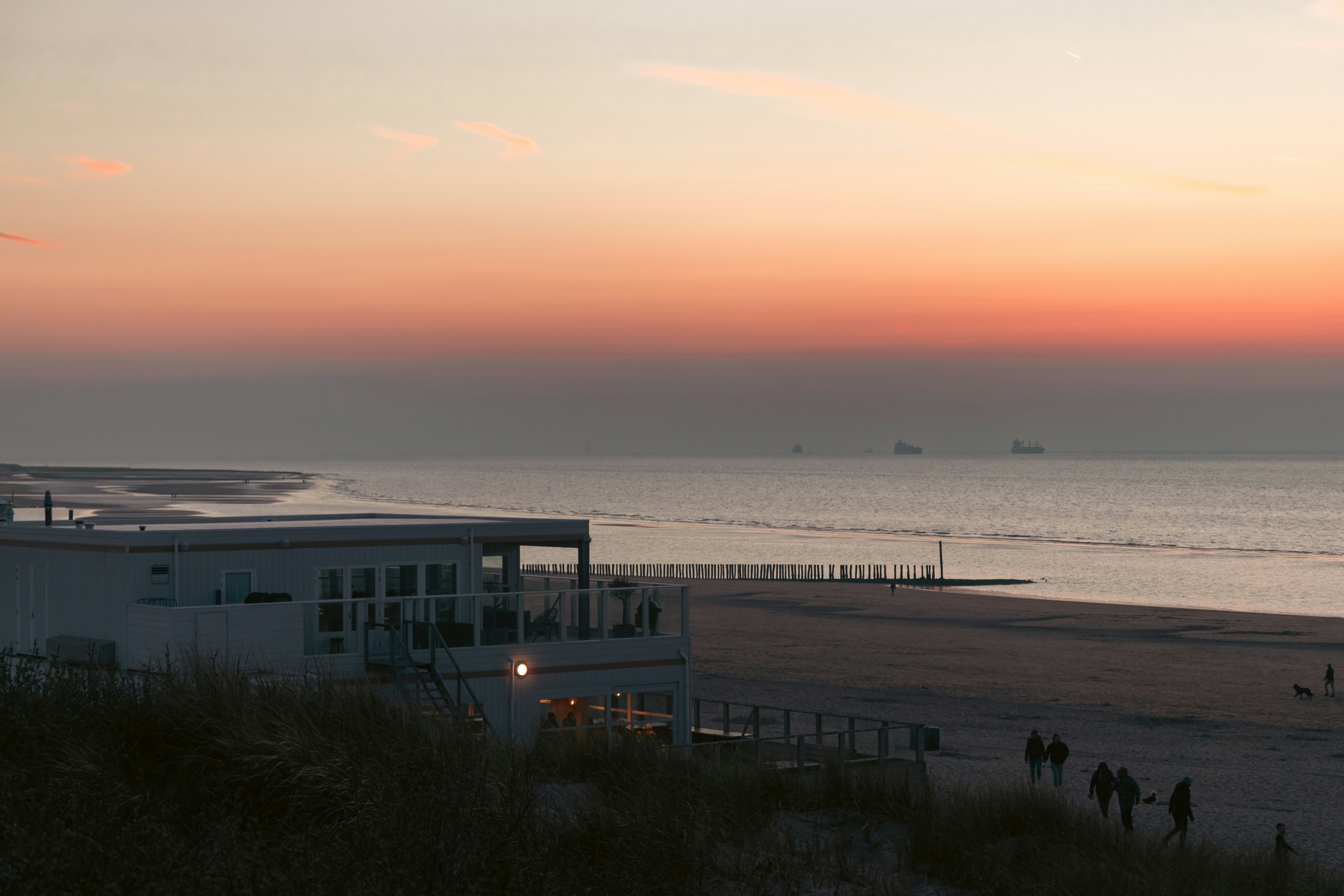 a group of people standing on top of a sandy beach