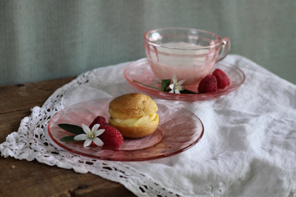 a plate with a muffin and some raspberries on it