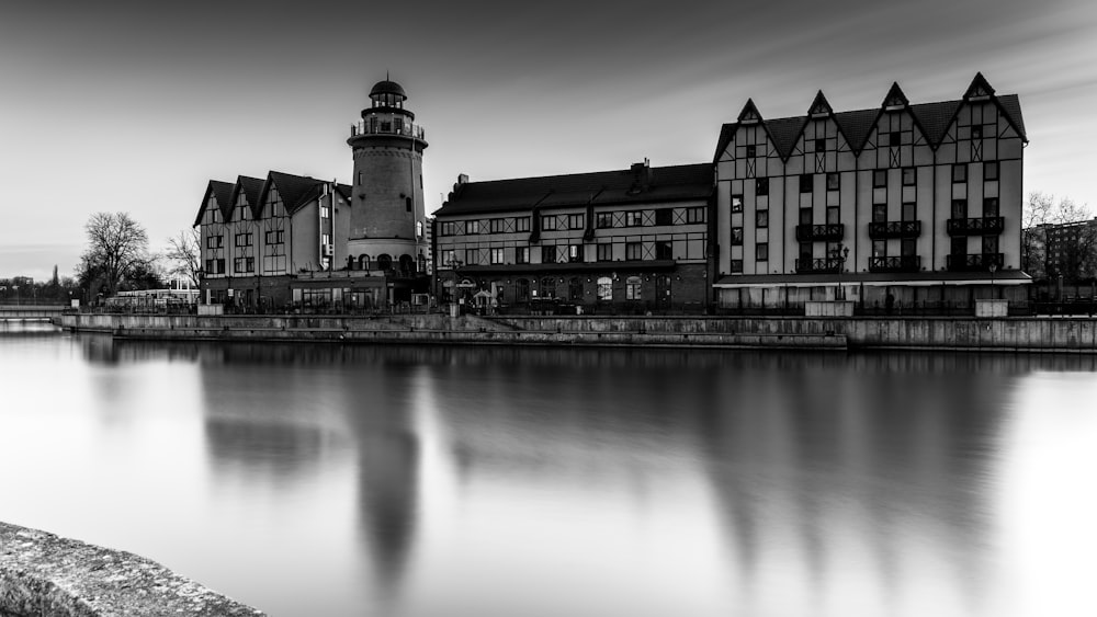 a black and white photo of a building and a body of water