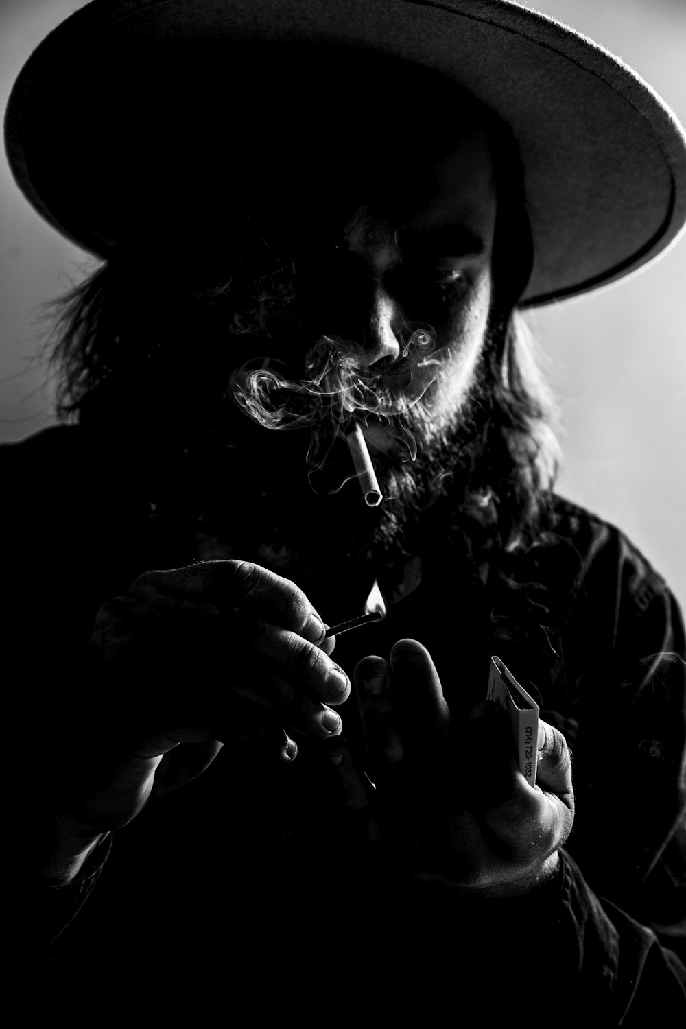 a man in a hat smoking a cigarette