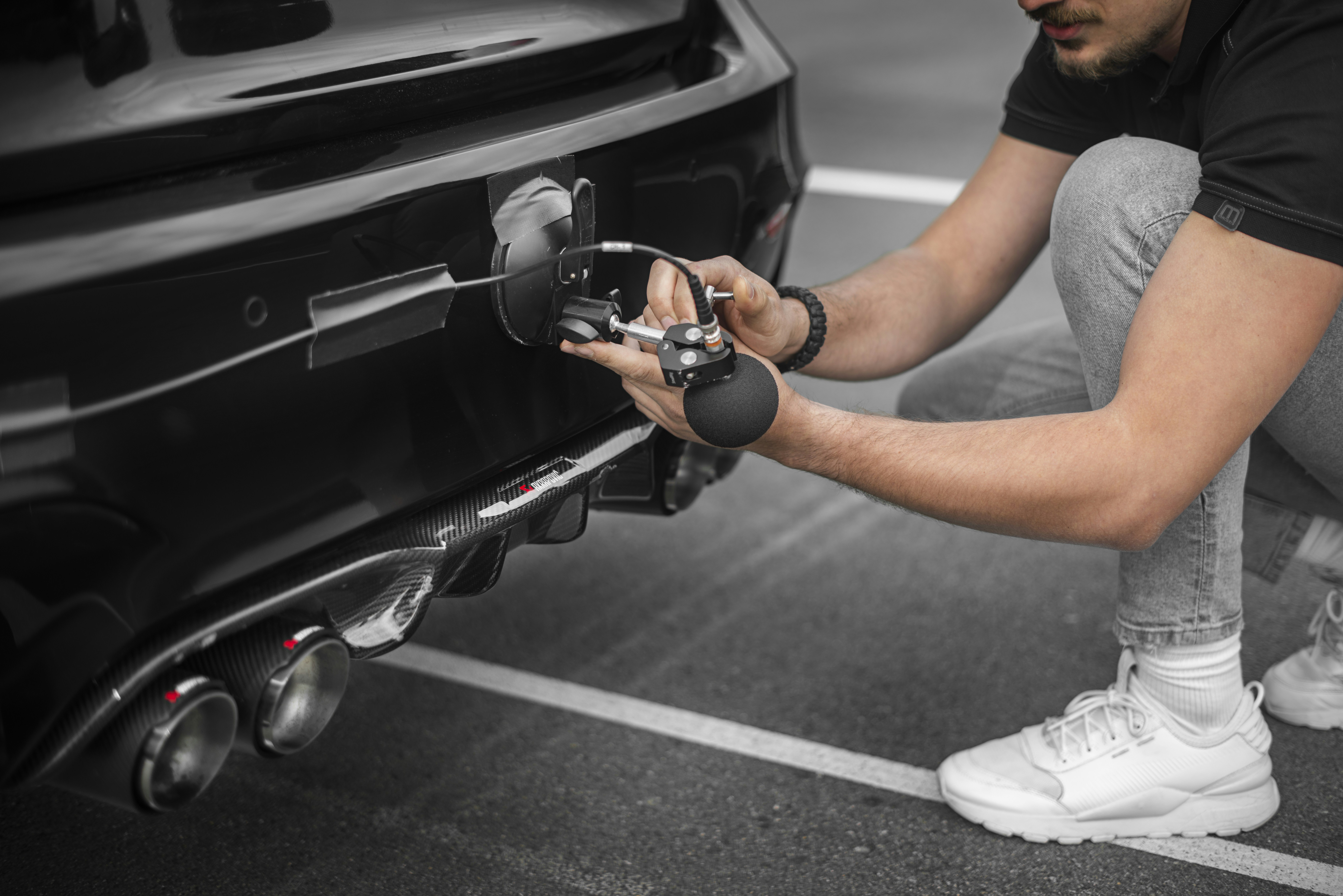 a man working on a car's front bumper