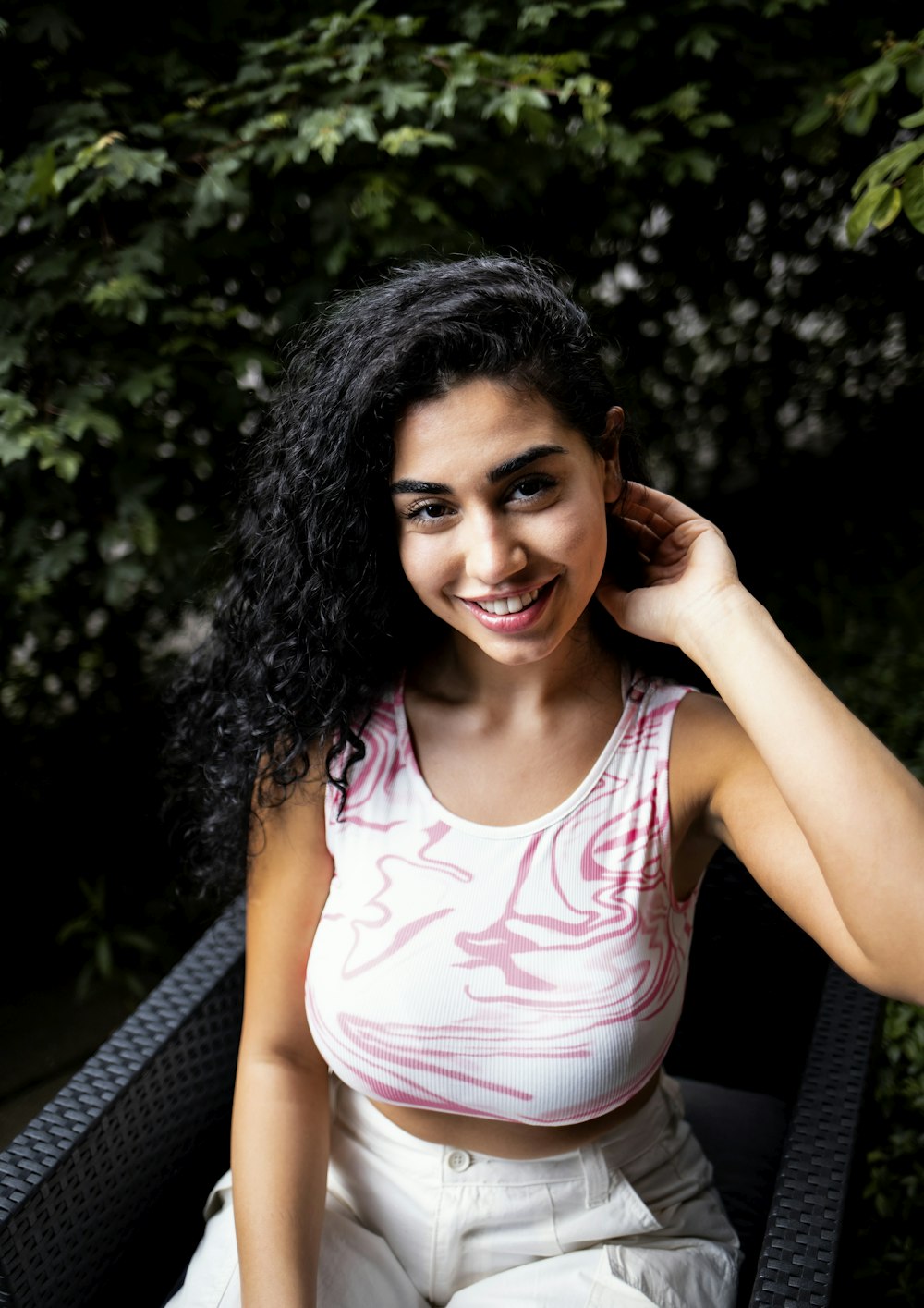 a woman sitting in a chair smiling at the camera