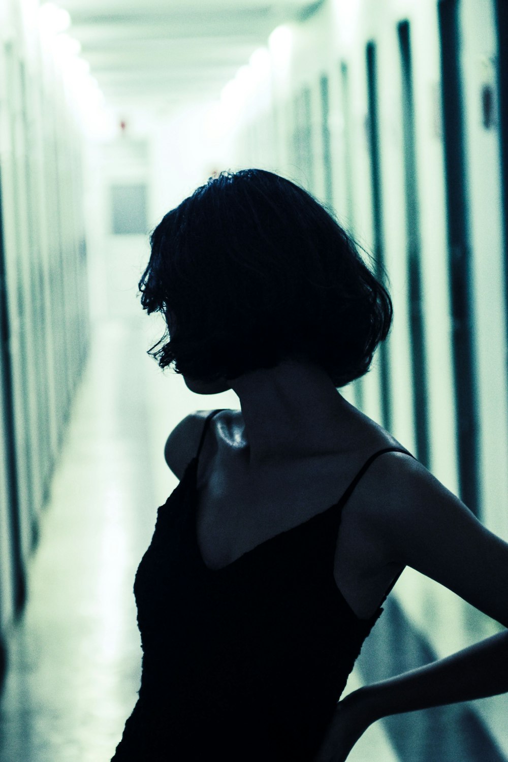 a woman in a black dress standing in a hallway