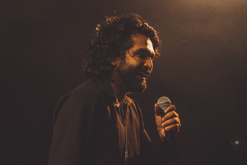 a man with long hair holding a microphone