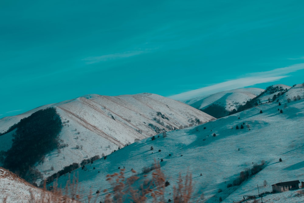 a snowy mountain with a house on top of it